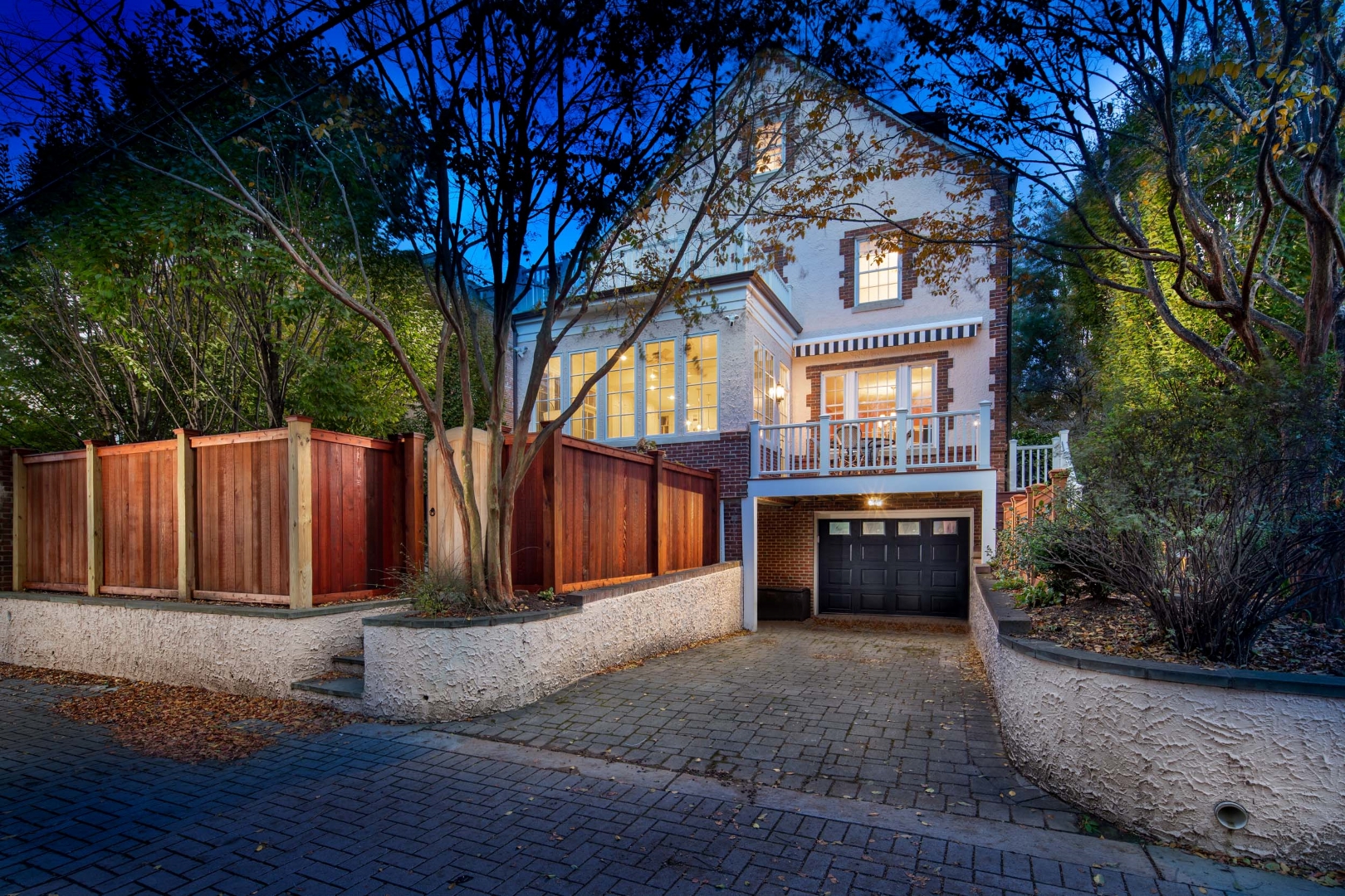 Cathedral property with rear exterior view showcasing garage and landscaping
