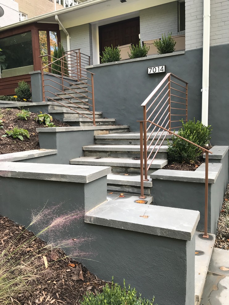 Modern home entrance featuring dramatic masonry walls, integrated seating area, and contemporary address display