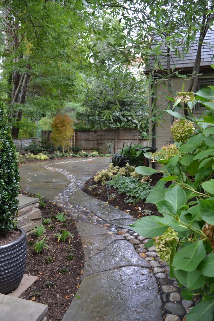 Irregular flagstone patio with river rock detail creating visual interest and natural drainage