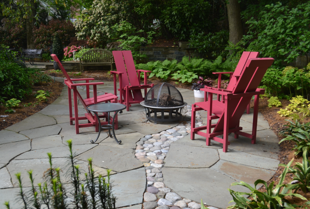 River rock 'stream' winding through irregular flagstone patio with Japanese maple focal point and shade-loving plants