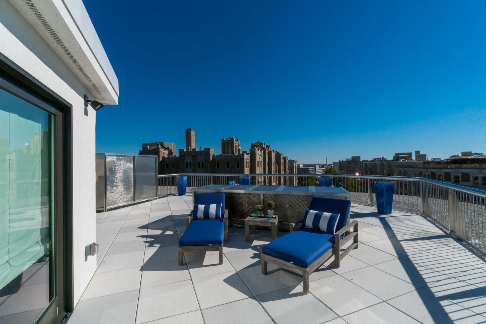 Transformed rooftop deck featuring custom railings, concrete pavers, and stunning city views for entertaining
