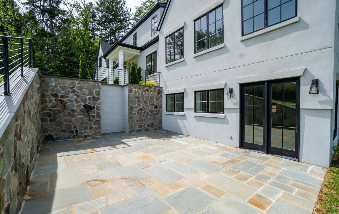 Rear view of modernized home with retractable glass walls opening to central courtyard designed for family entertaining