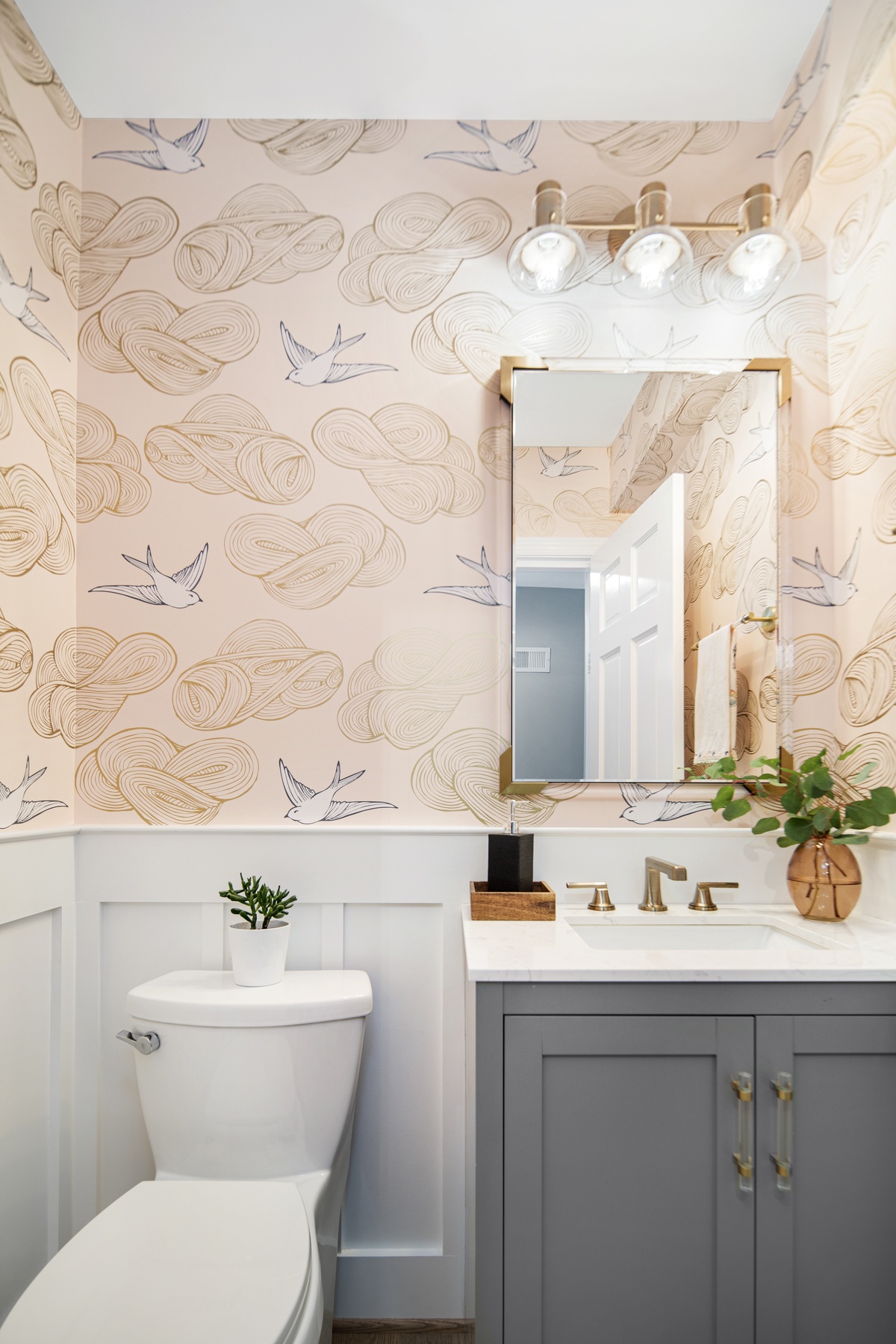 Stylish powder room with designer wallpaper, modern sink fixture, and carefully selected lighting elements