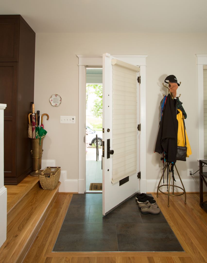 Contemporary entryway with thoughtful lighting, artistic details, and transitional design elements in Shepherd Park home