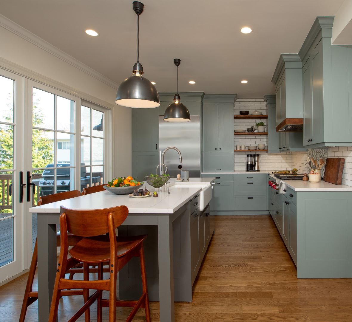 Completely reimagined Takoma Park kitchen featuring green/gray cabinetry, dark wood accents, and strategic relocation to back of house connecting to outdoor deck