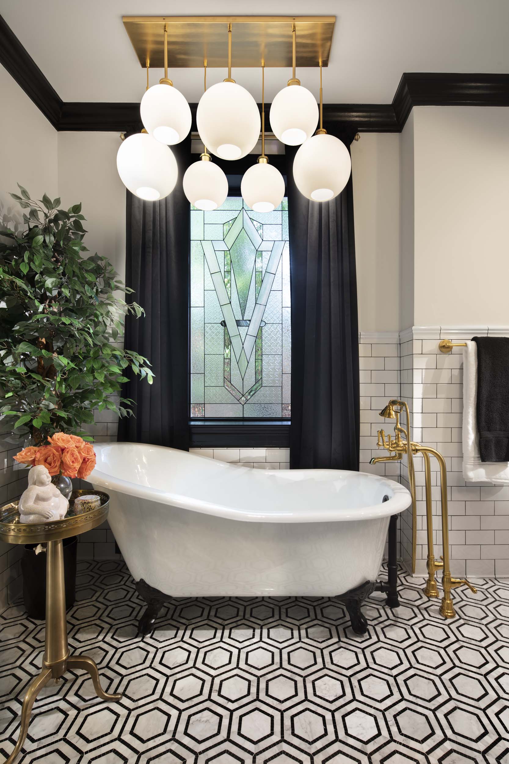 Primary bathroom with freestanding tub, custom vanity, and elegant finishes continuing the classic black and white theme