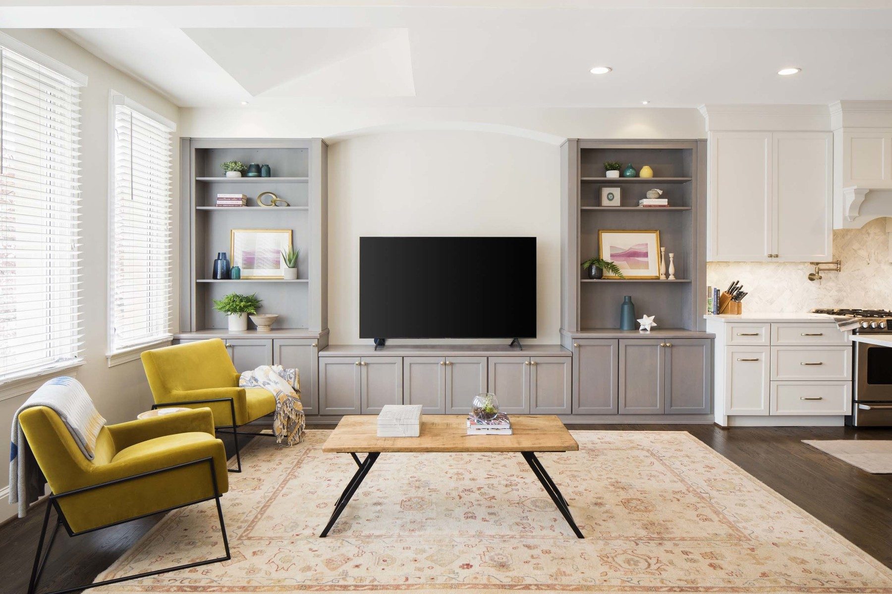 Kitchen featuring pale gray island, white shaker cabinets, and mixed metals creating clean contemporary aesthetic