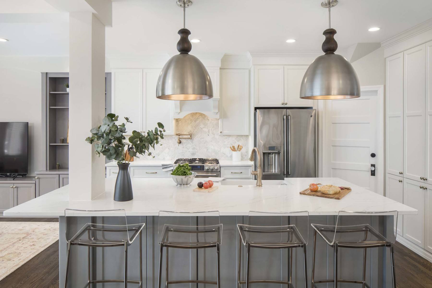 Open concept kitchen with island, modern lighting, and thoughtful design elements in renovated Glover Park home