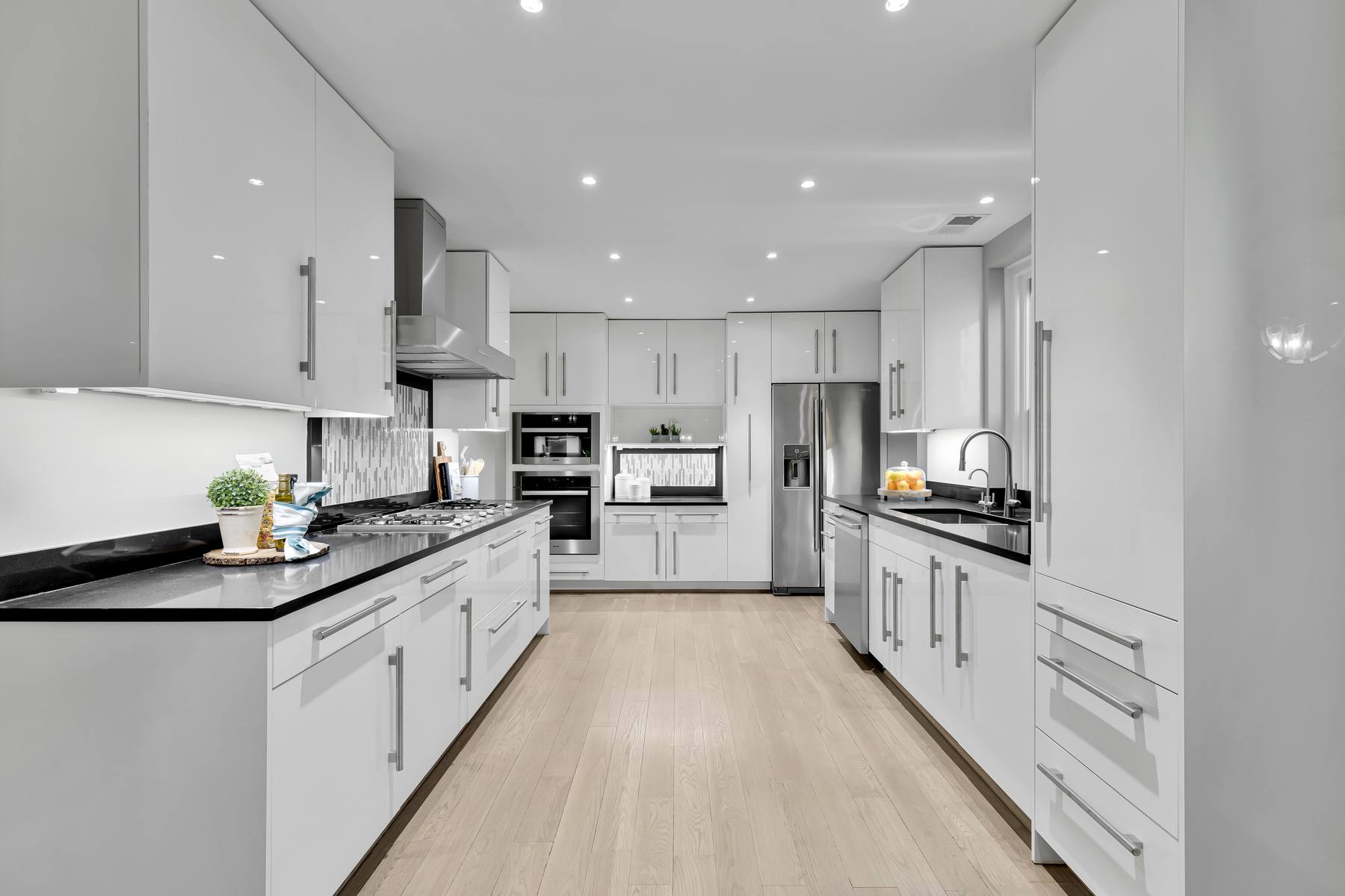 Modern kitchen featuring sleek white cabinetry, premium appliances, and sophisticated lighting in historic Kalorama co-op