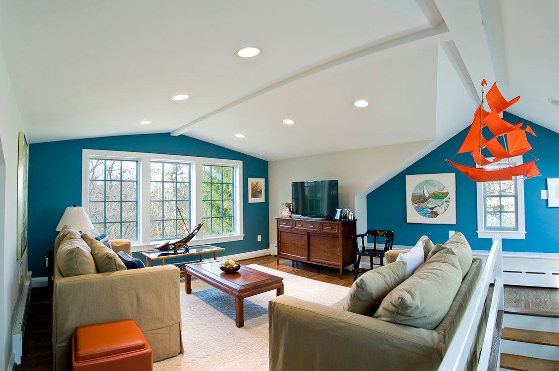 Comfortable seating area in renovated attic with large windows framing picturesque Potomac River landscape