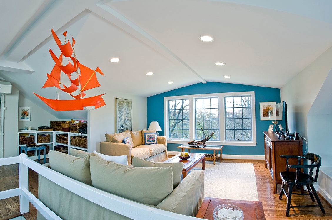 Open-concept attic living area with vaulted ceilings, modern furnishings, and expansive windows showcasing river views
