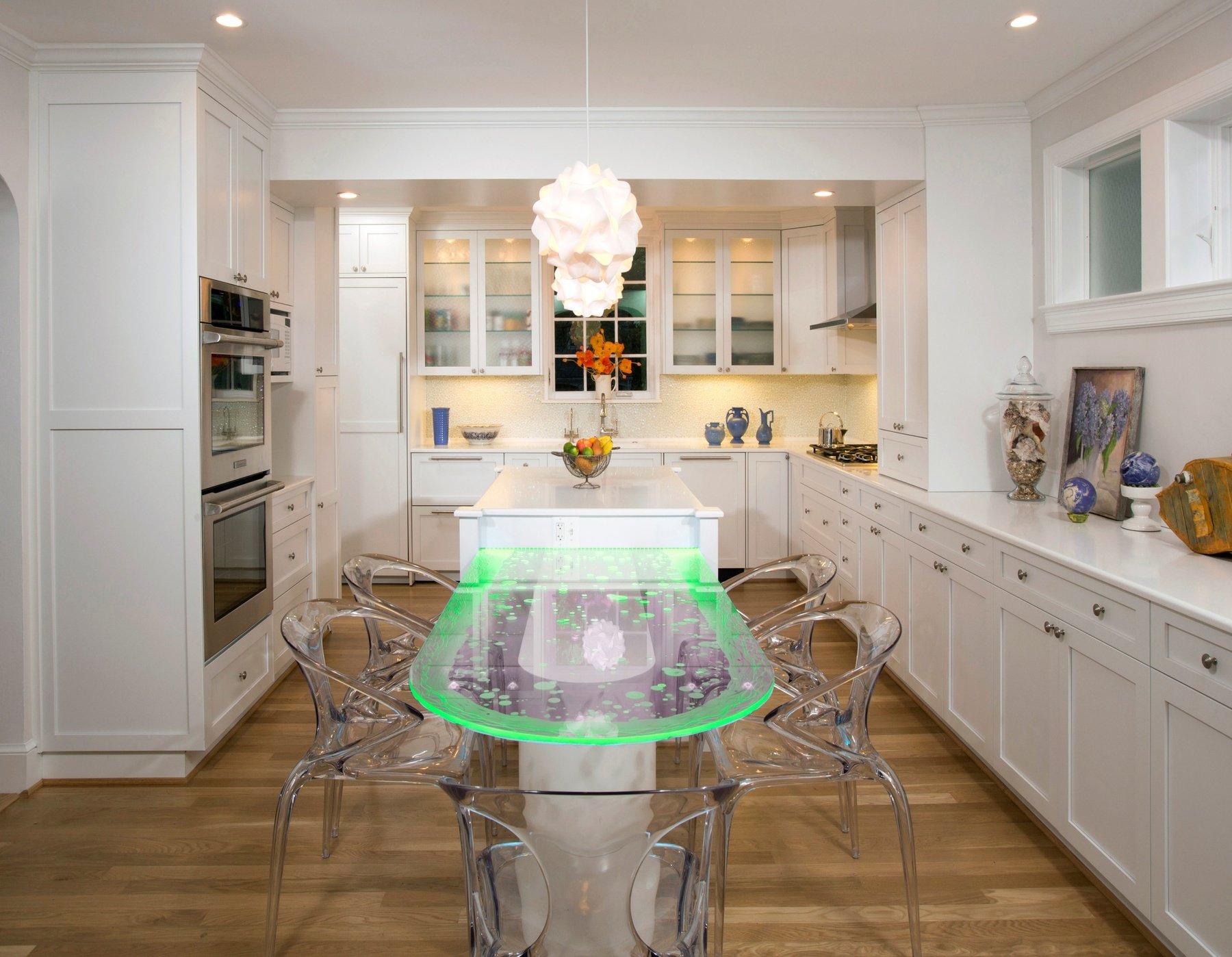 Open concept kitchen showing connection to dining and family rooms with continuous wood flooring