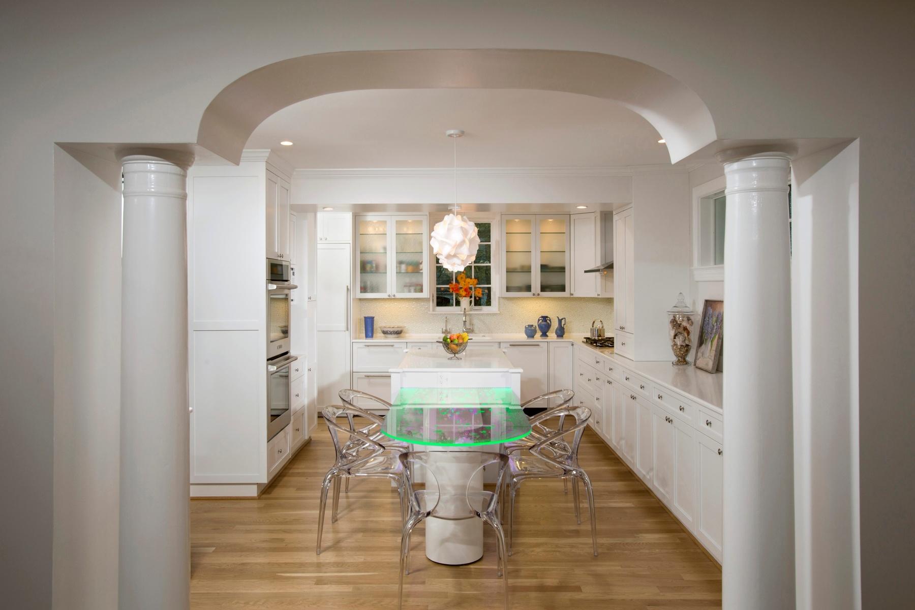 Detail of illuminated glass table showing bubble motif that coordinates with glass cabinet doors in white kitchen