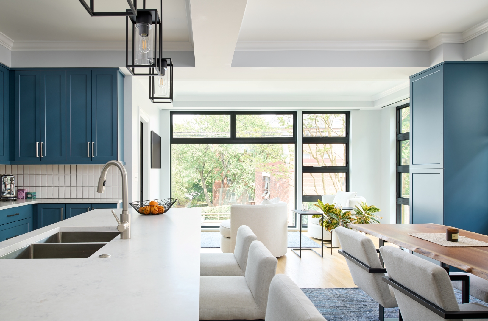 Modern kitchen renovation in Woodley Park featuring dark blue cabinetry, open floor plan, and abundant natural light in single-story addition