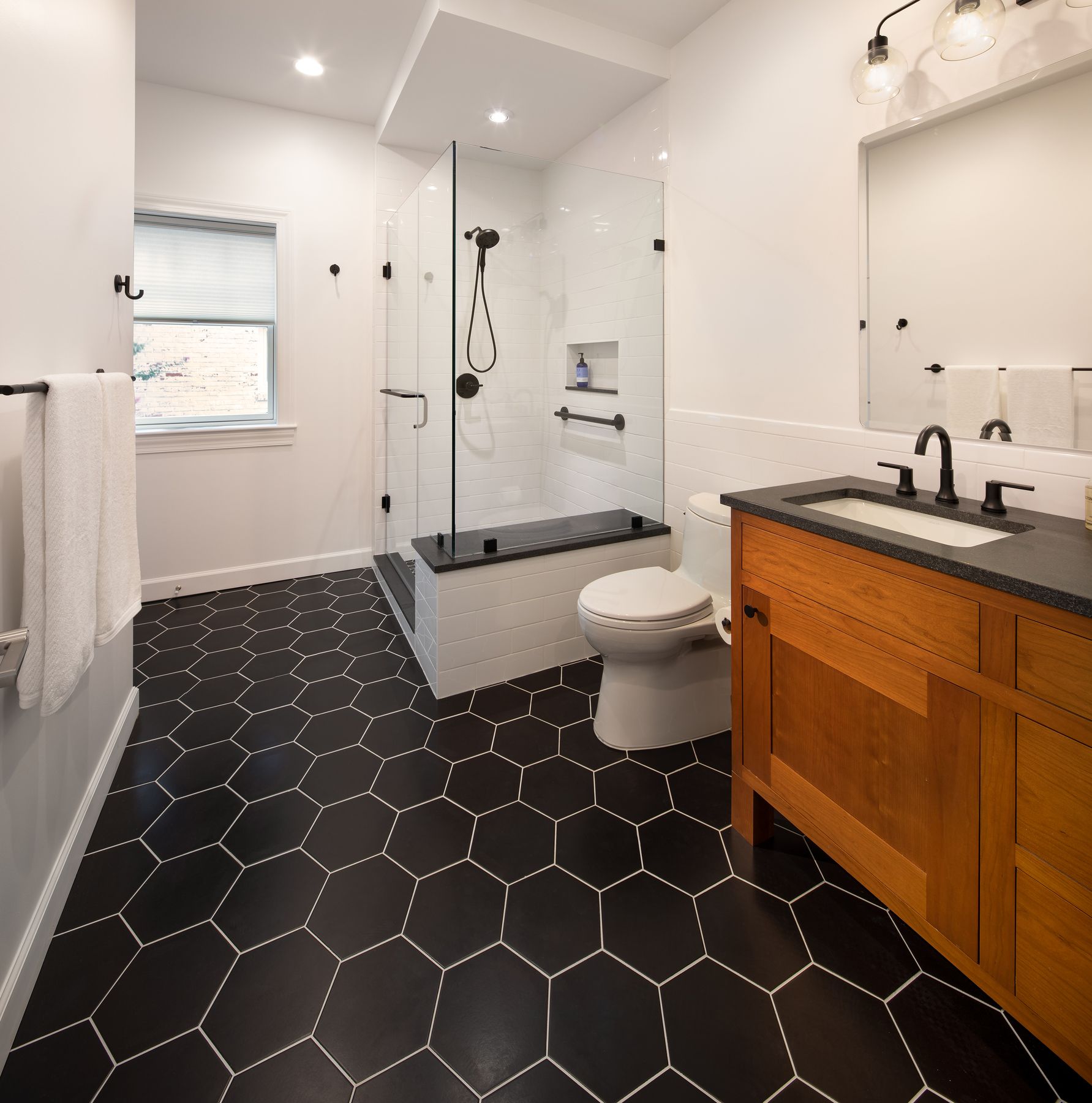 Renovated bathroom featuring contemporary fixtures, elegant tile work, and thoughtful design in expanded home