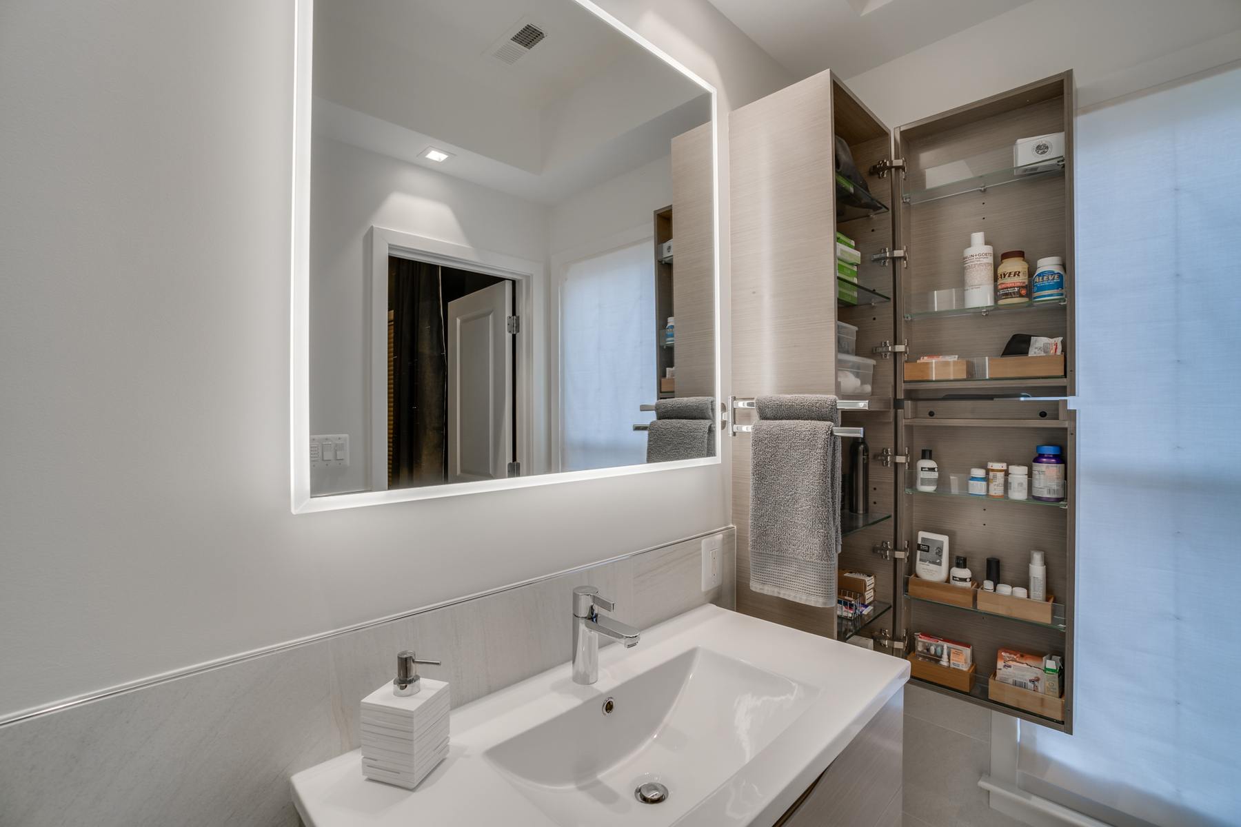 Modern lighting fixtures in renovated kitchen creating bright, contemporary atmosphere in Capitol Hill rowhouse