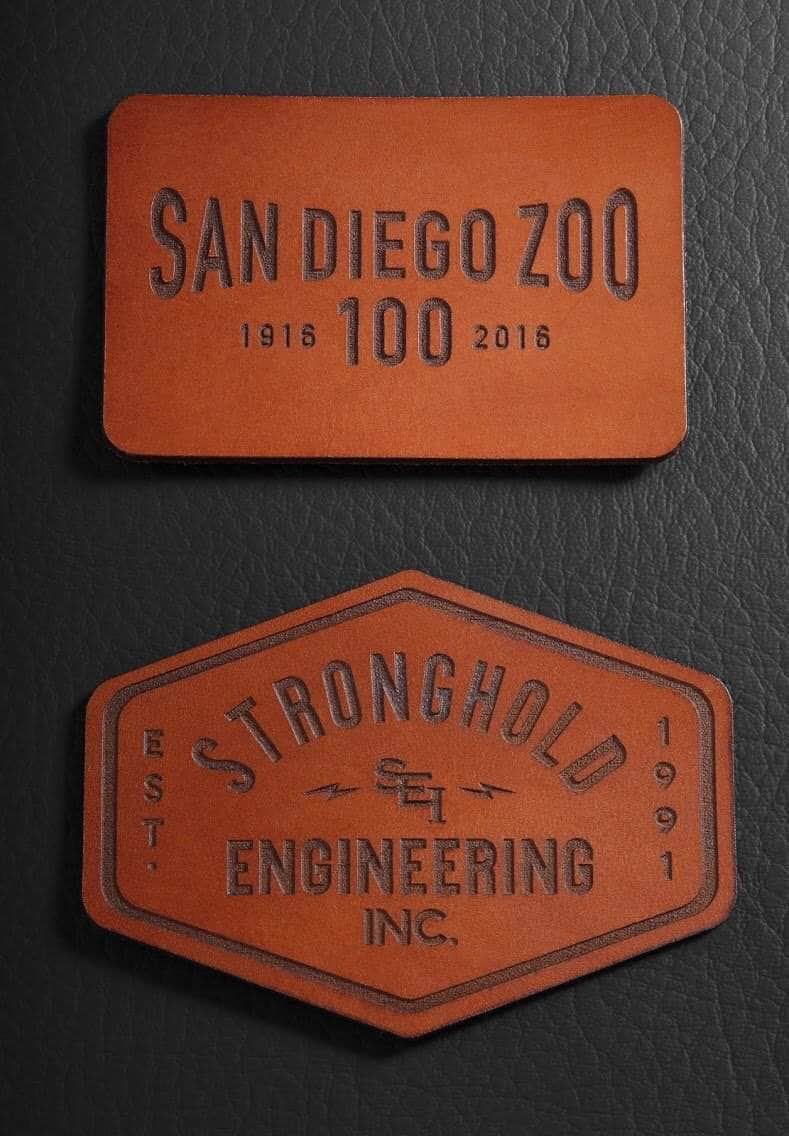 Custom engraved leather patches, one rectangular and one hexagonal