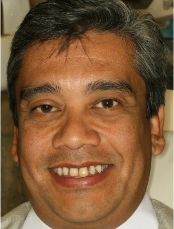 Close-up of a smiling middle-aged man with salt-and-pepper hair and brown eyes.