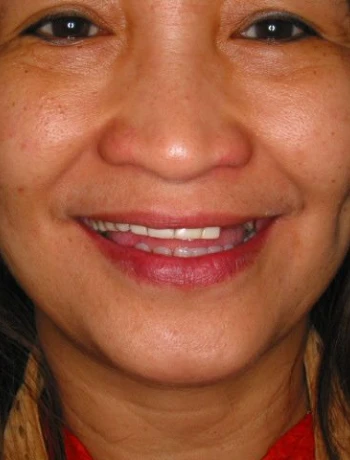 Close-up of a smiling person with medium skin tone and dark hair.