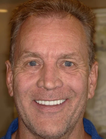Middle-aged man with light brown hair and blue eyes smiling at the camera.