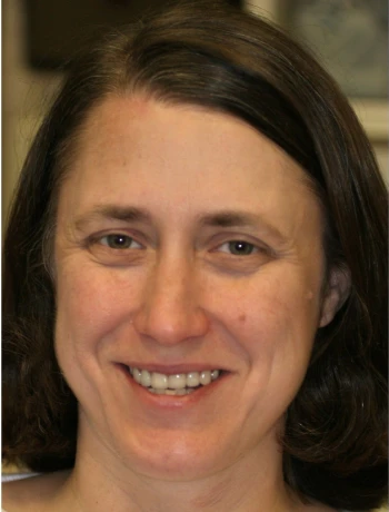 Close-up of a smiling woman with shoulder-length dark hair and brown eyes.