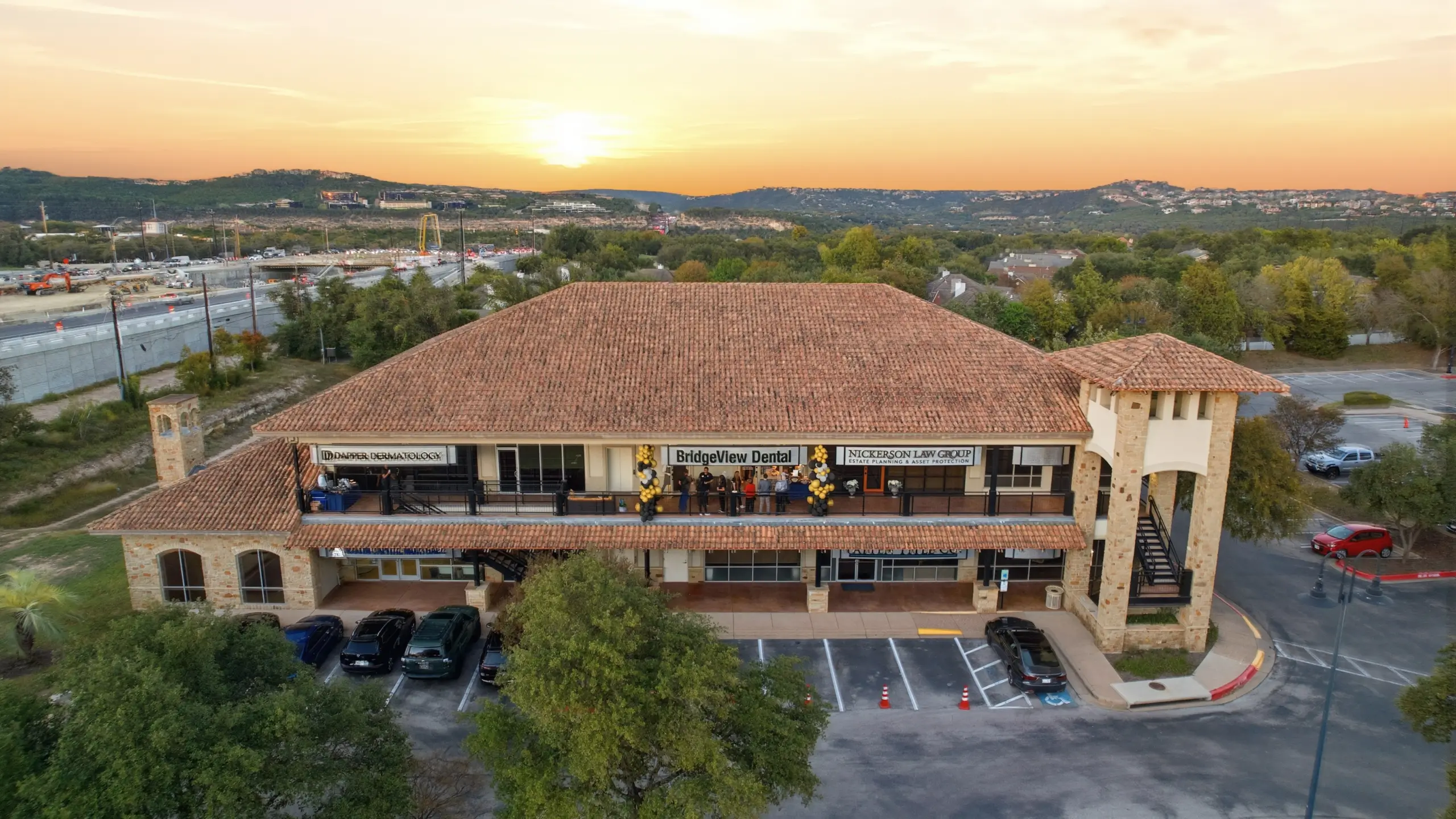 A two-story commercial building at sunset with signs for BridgeView Dental, Nickerson Law Group, and Dr. Danifer Dermatology.