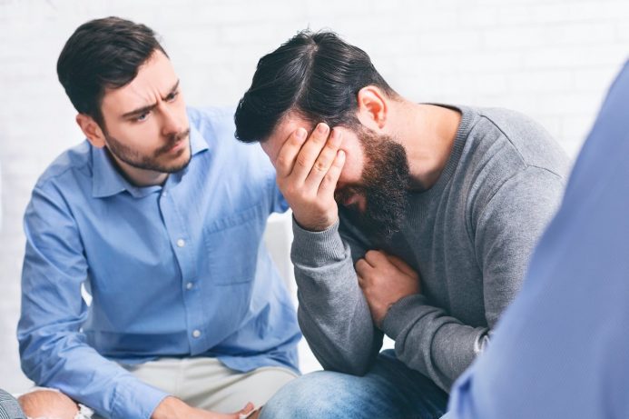 Patients comforting each other in men's rehab program