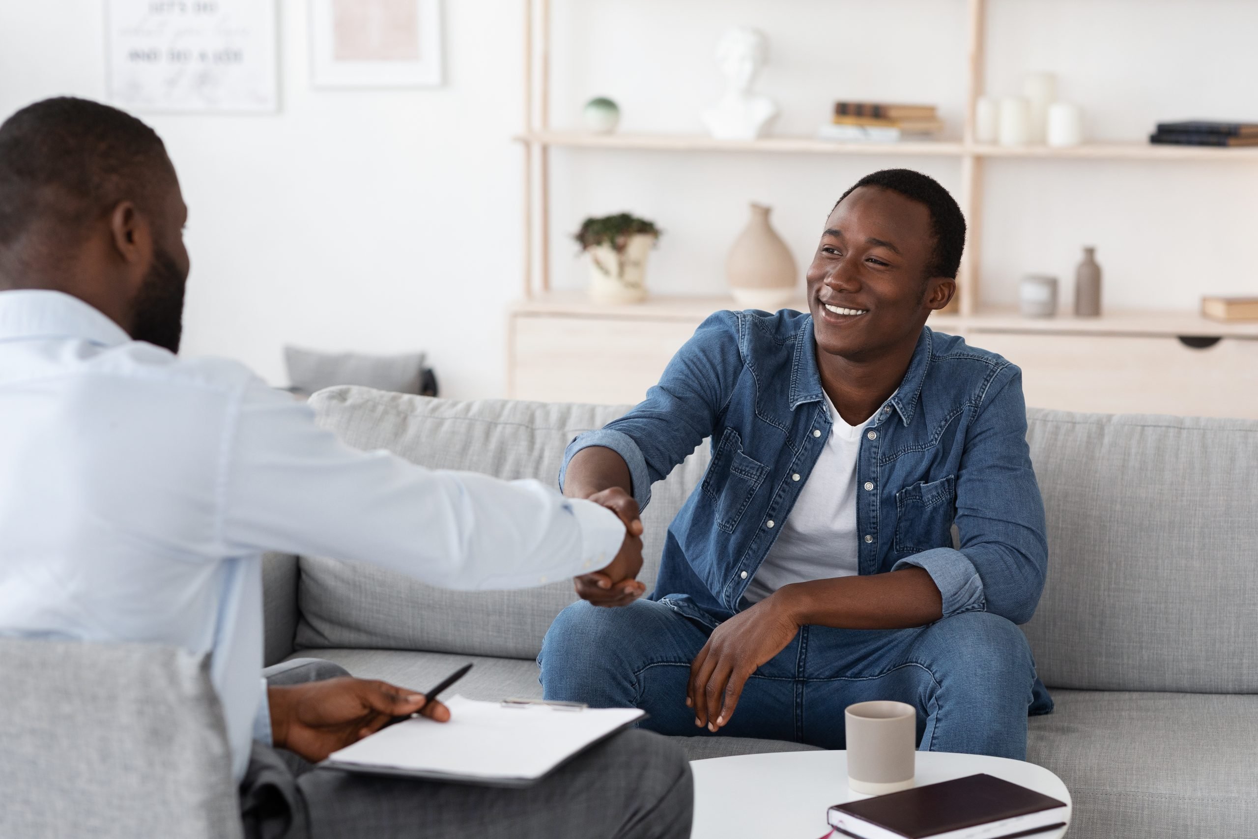 two african american men shaking hands and smiling