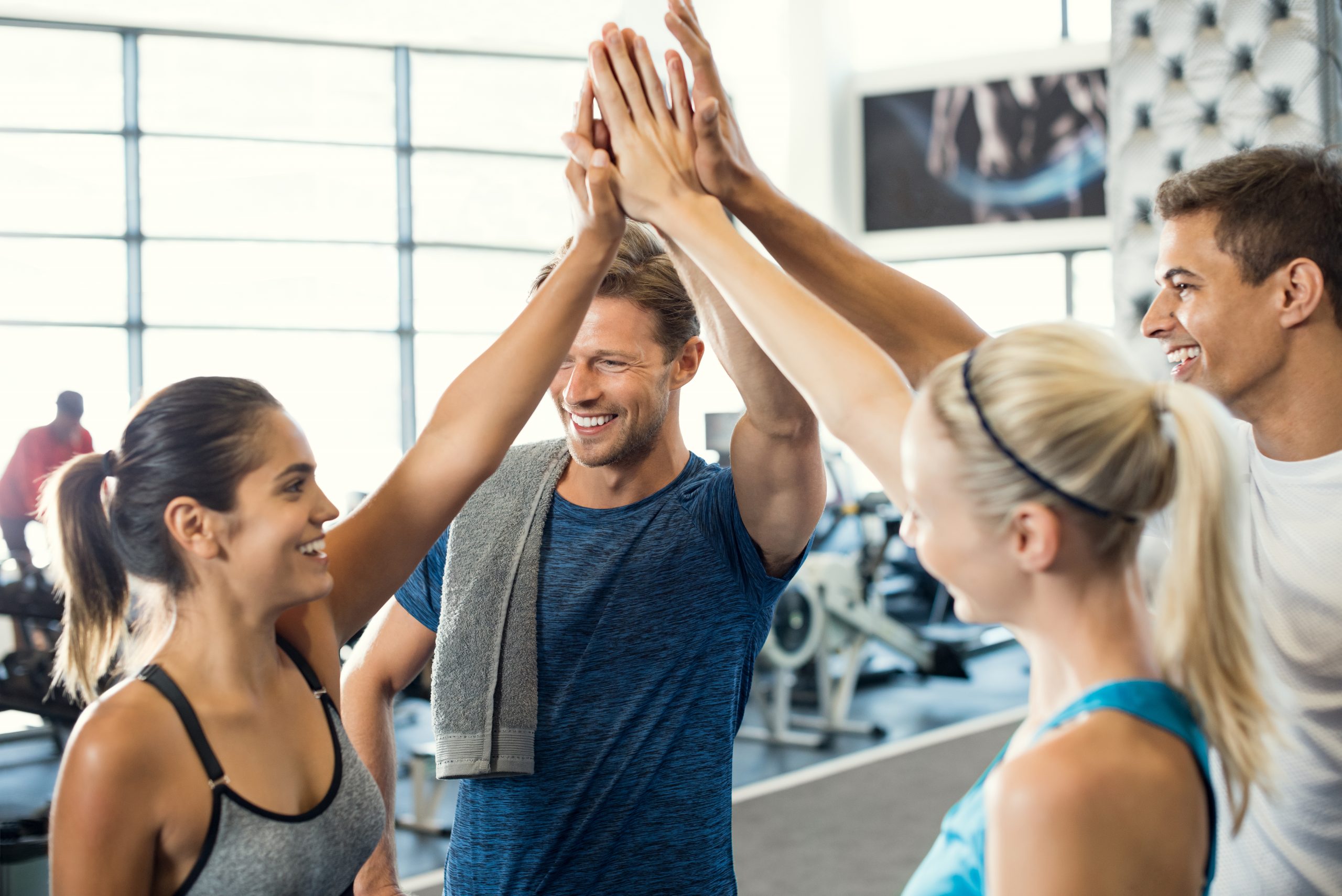 group of women and men in a group exercise class giving a high five