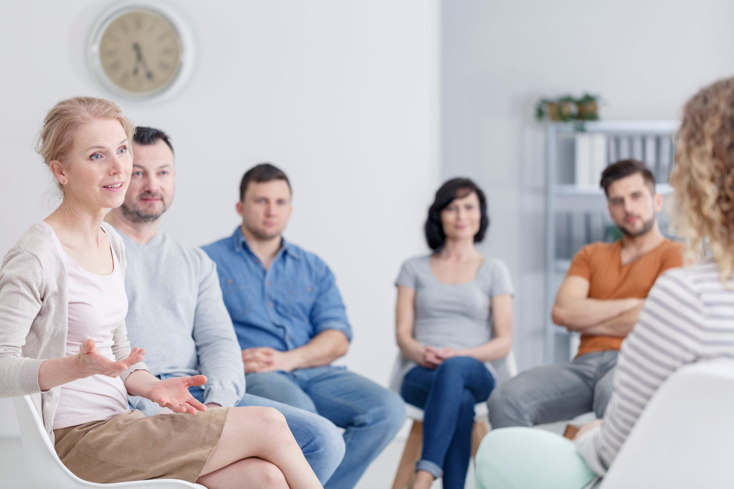 female speaking to her peers in an aa meeting