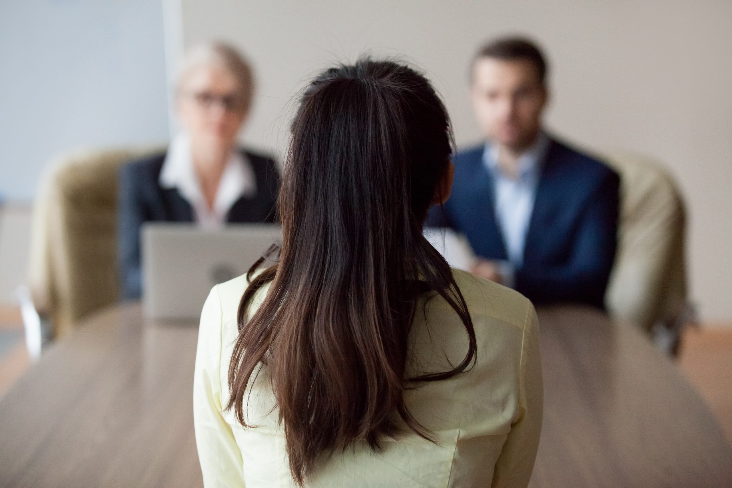 a woman with her back facing the camera in a job interview