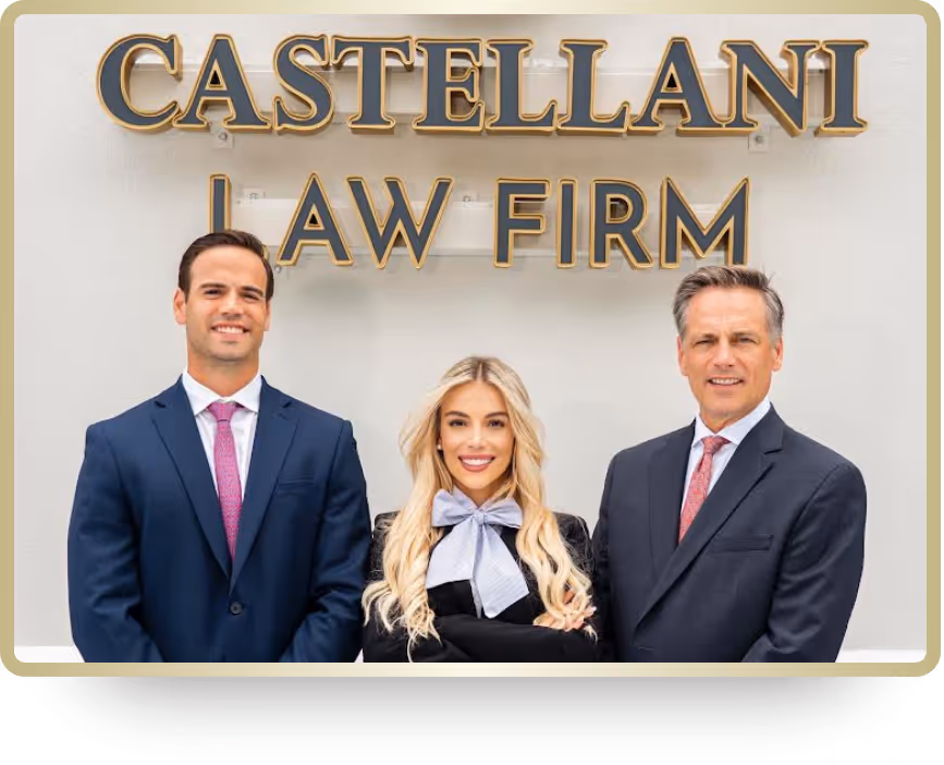 Three professionally dressed people standing and smiling in front of a sign that reads Castellani Law Firm.