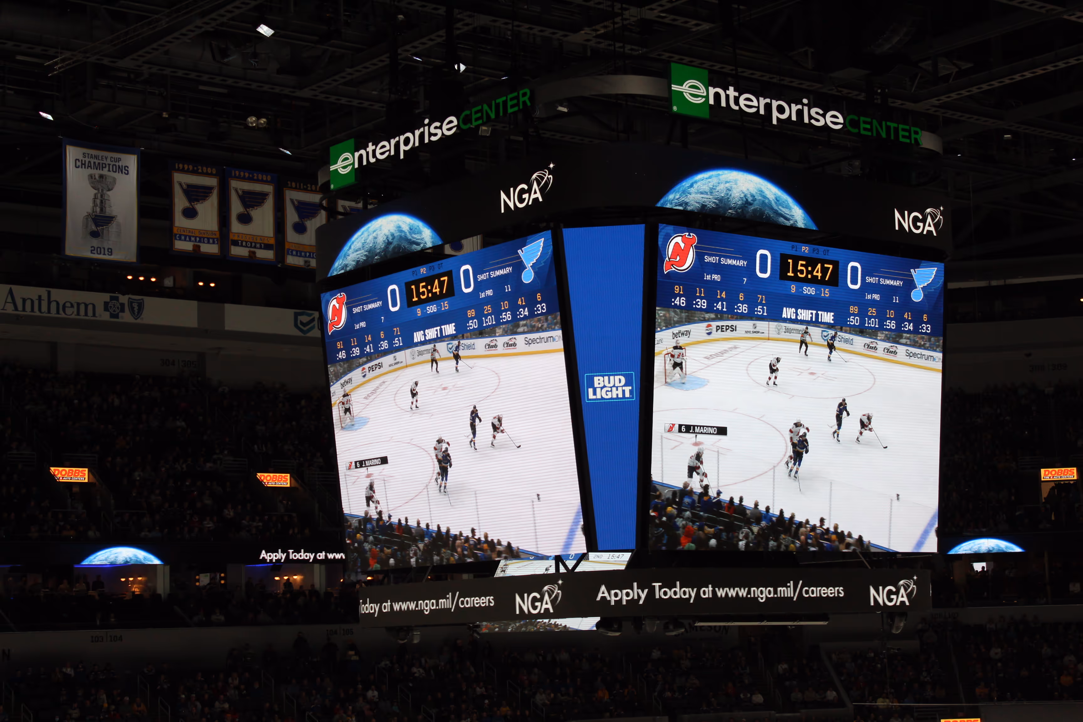 Jumbotron scoreboard at Enterprise Center showing a hockey game between New Jersey Devils and St. Louis Blues with score tied 0-0 and 15:47 remaining in the first period.