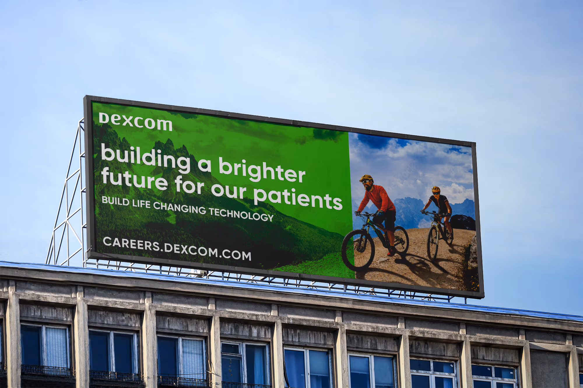 Billboard with Dexcom logo and message about building a brighter future for patients, showing two cyclists riding on a mountain trail.