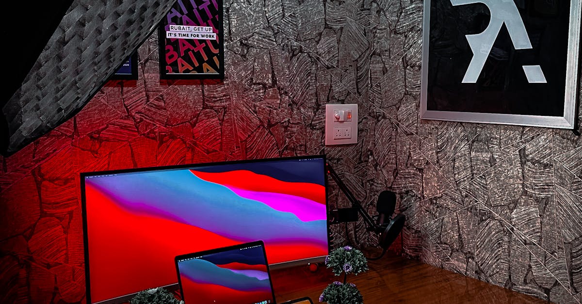 A sleek and tech-heavy home office setup with screens, keyboard, and stylish lighting.