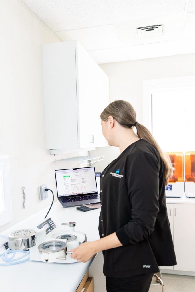 orthodontic tech in lab uses EasyRx's lab prescription form software on laptop  to manage appliance production