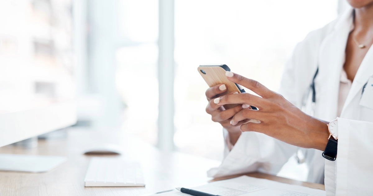 doctor uses phone at desk