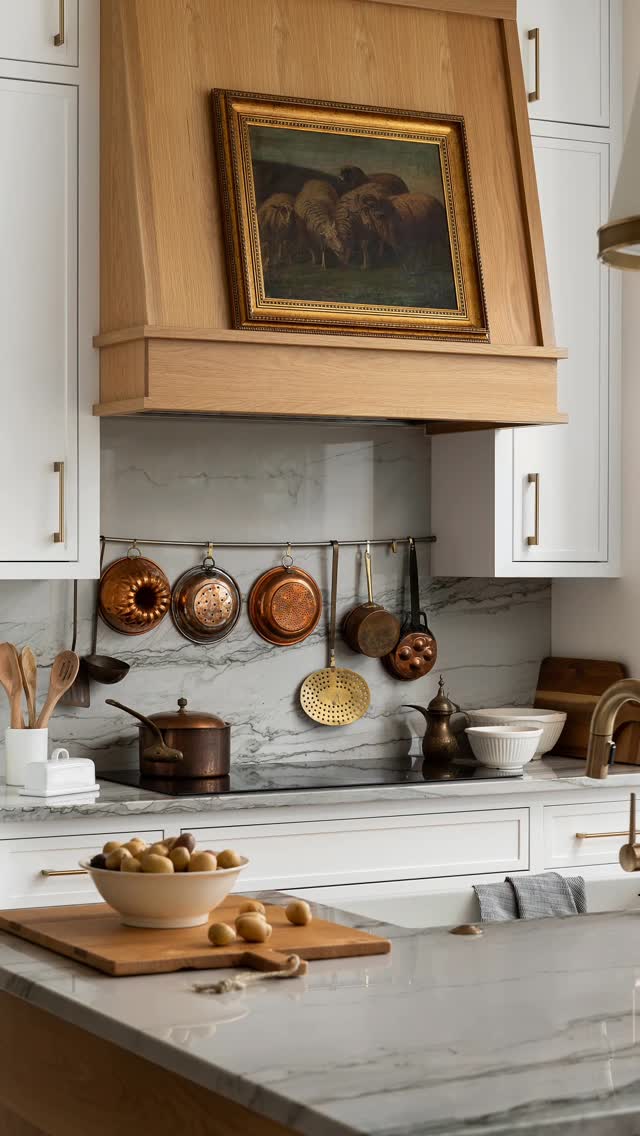 Kitchen interior with warm wood cabinetry, styled shelving, and layered decor.