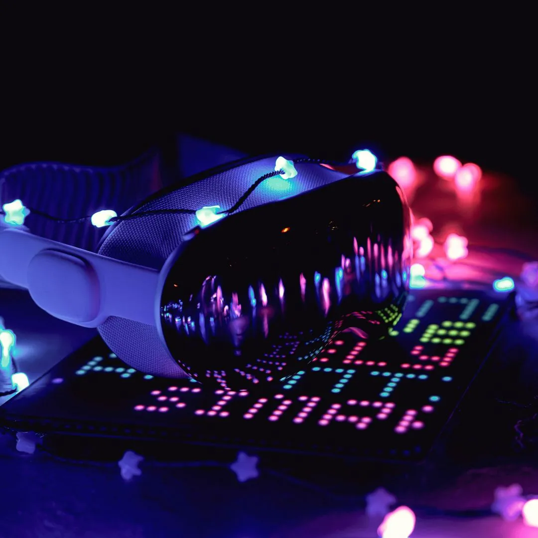 Virtual reality headset with star-shaped blue and pink fairy lights reflecting on its surface and nearby.