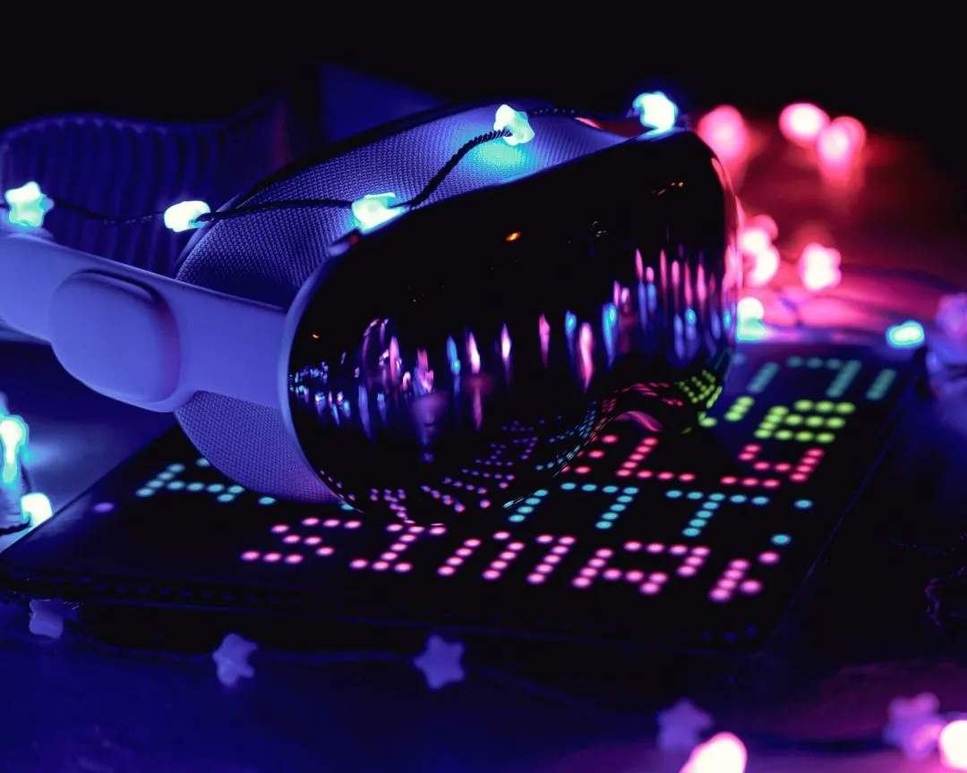 White virtual reality headset with glowing blue star-shaped lights on a colorful illuminated surface.