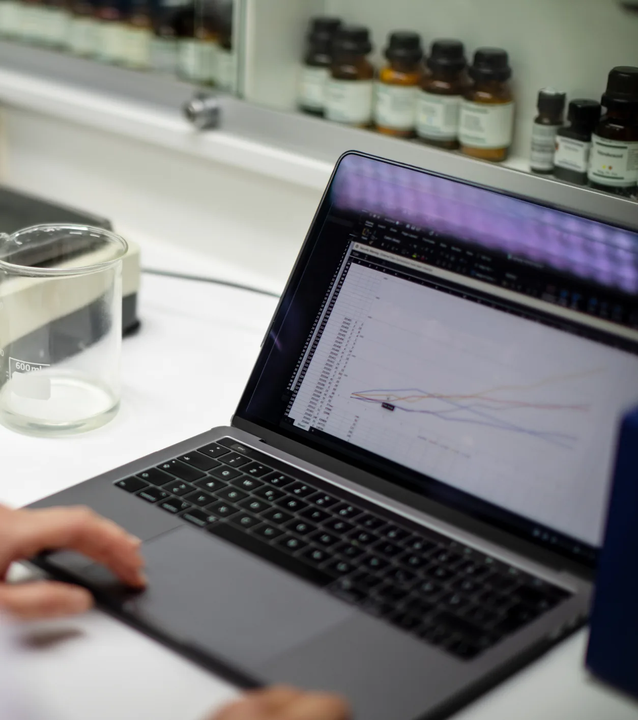 Laptop showing clinical data charts on a laboratory bench