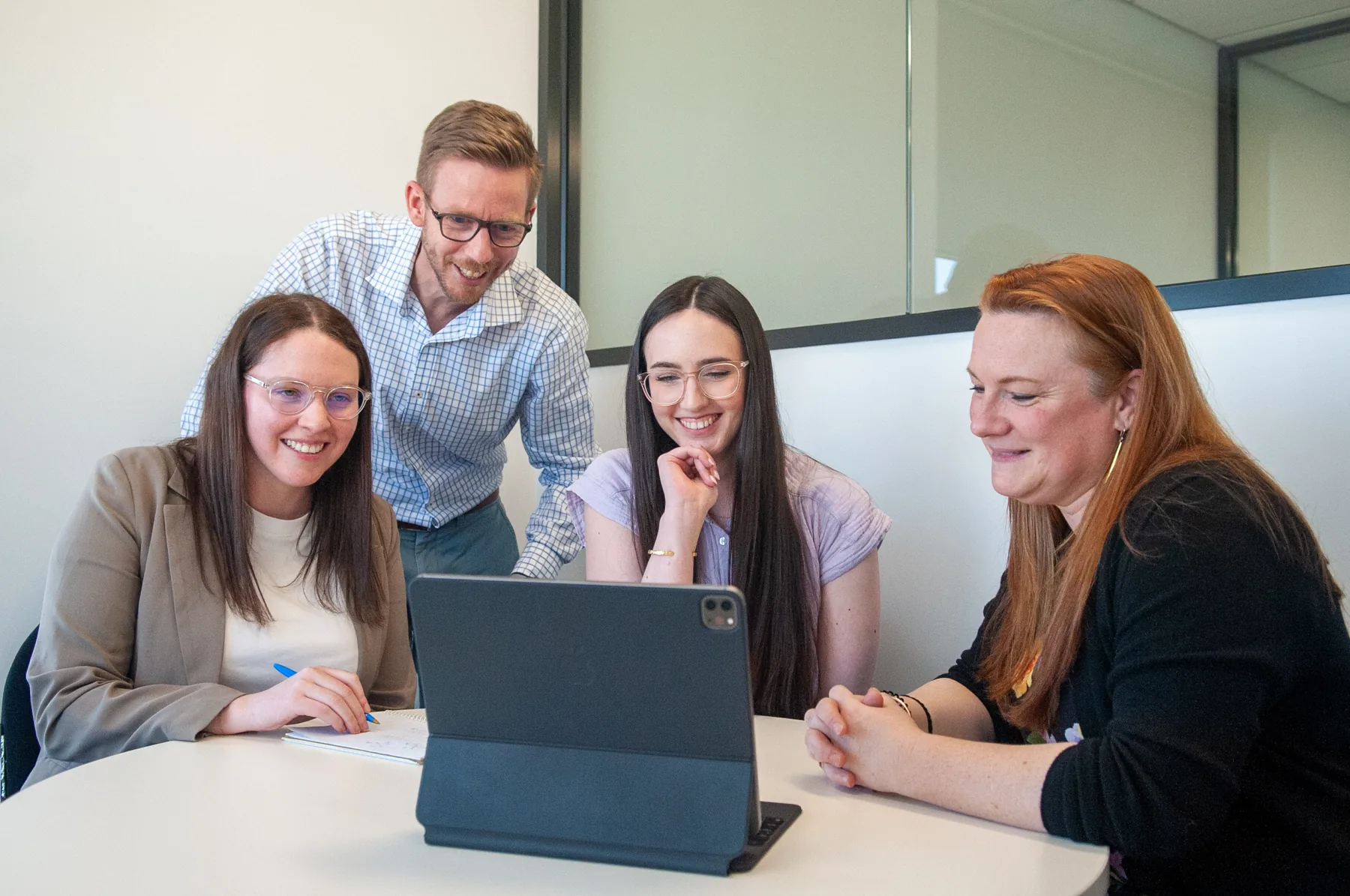 Four Accelagen team members working together around a tablet