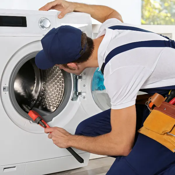 Appliance technician performing dishwasher repair in a Mira Mesa kitchen, using a power tool to fix the door assembly.