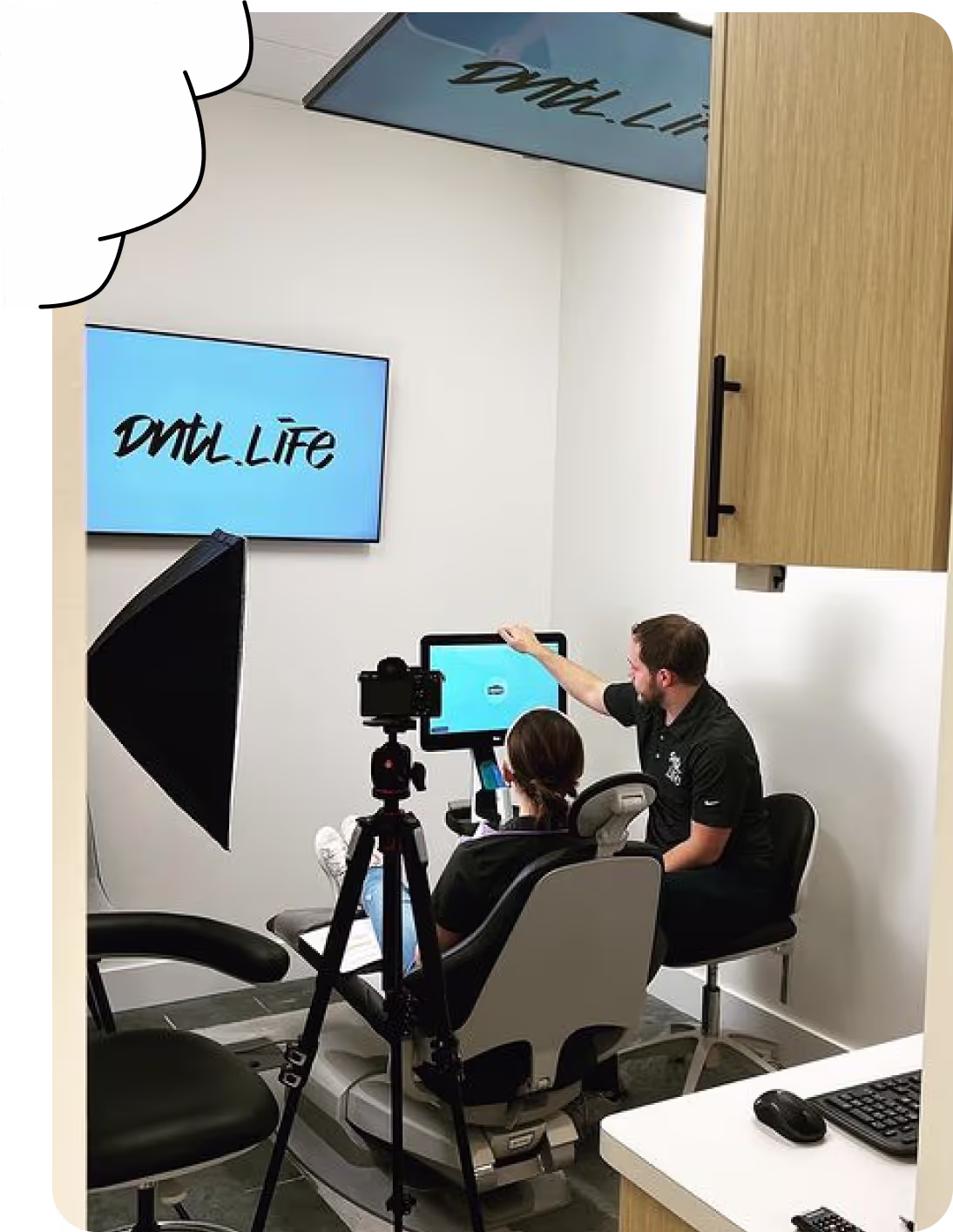 a woman sitting in a dental clinic with a man looking at the monitor