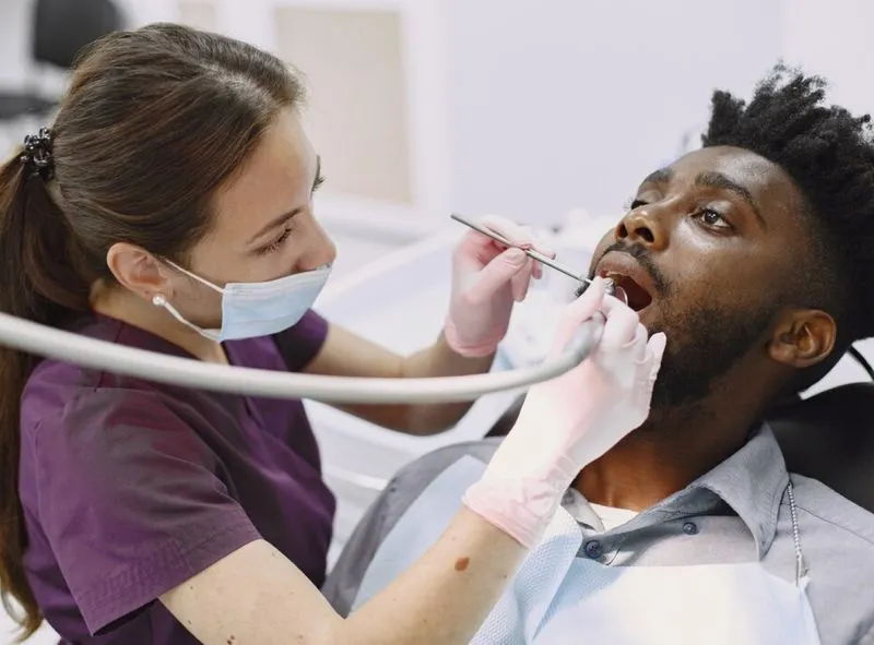 a woman checking inside the mouth of a man
