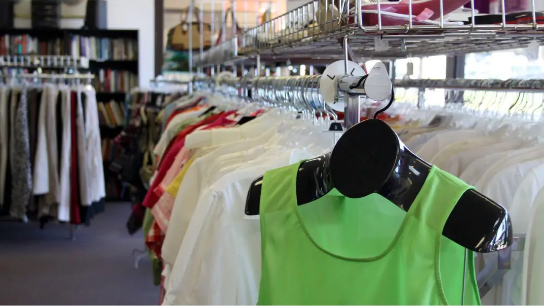 A vibrant green top displayed on a hanger in a clothing store.