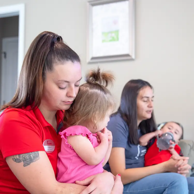 A nurturing moment of a mother praying with her child in a cozy home environment.