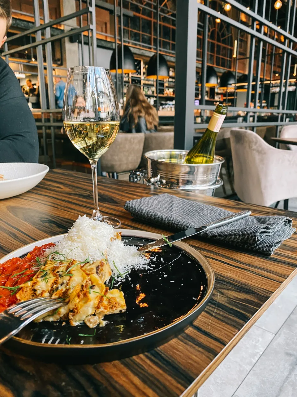 Gemütlich gedeckter Restauranttisch mit verschiedenen Speisen und Getränken in stilvollem Ambiente.