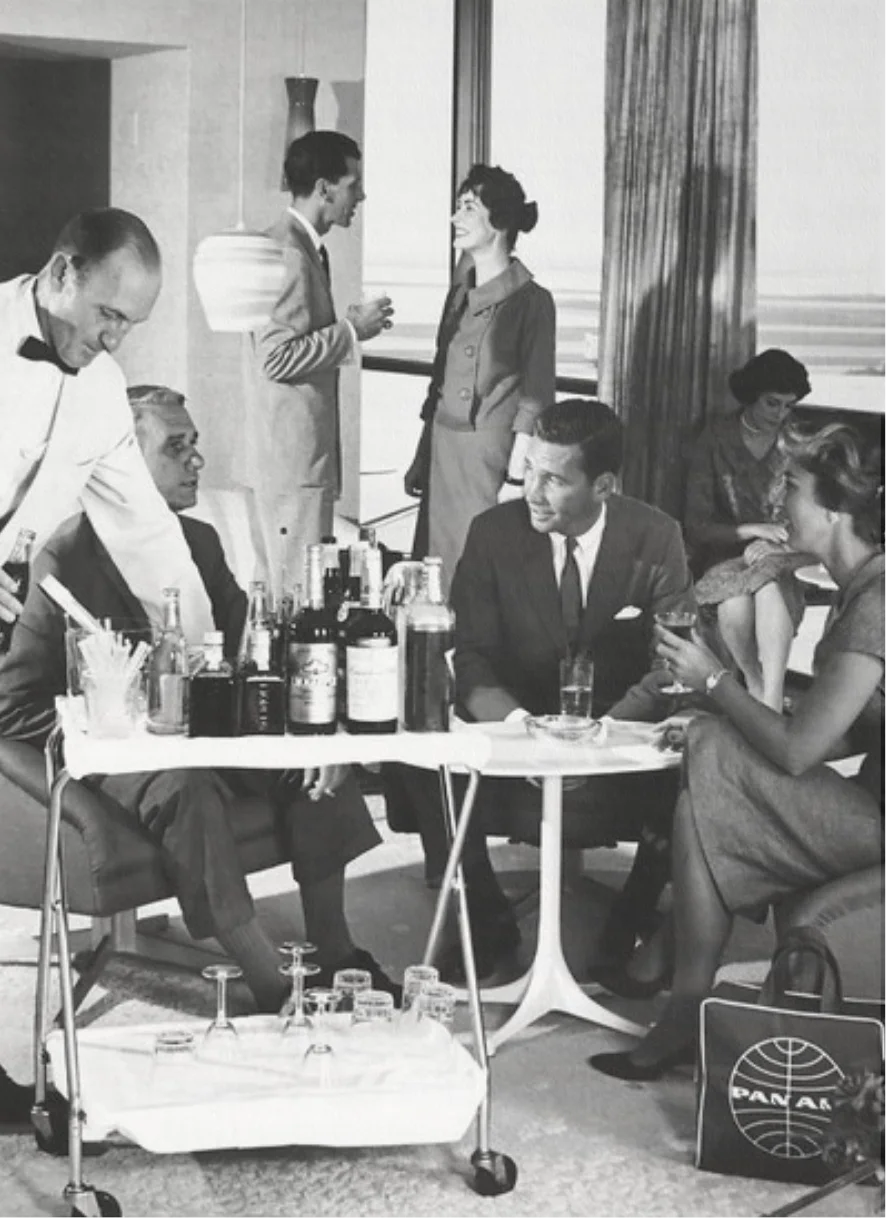 People relaxing in a lounge setting, while being served drinks off a metal cart into crystal glasses