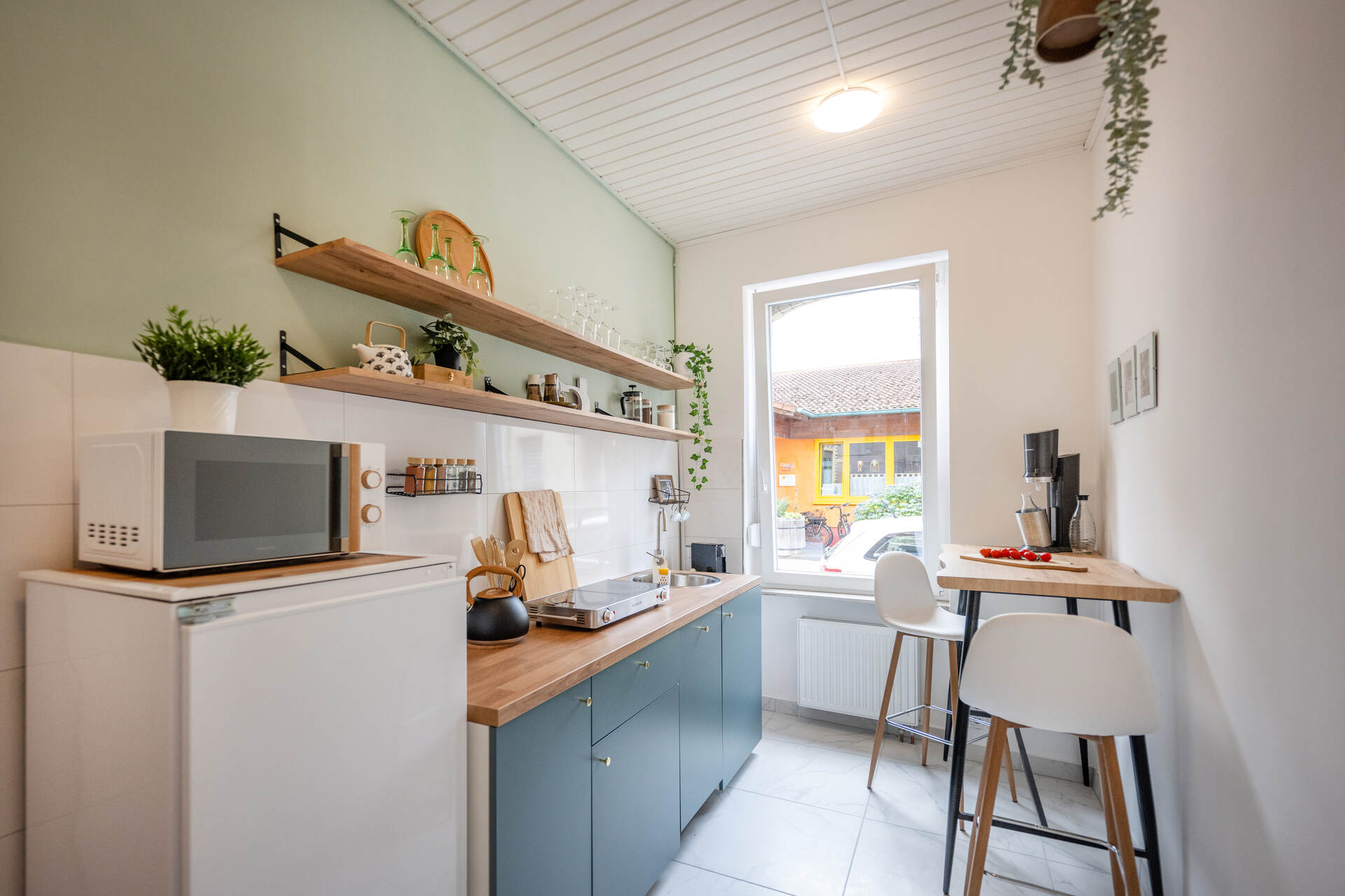 Voll eingerichtete Küche mit Blick auf Sitzecke und Kühlschrank